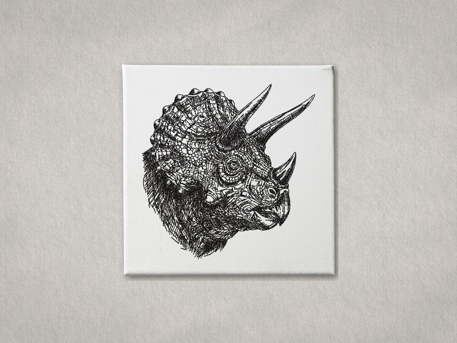 Detailed black embroidered Triceratops head on white gallery-wrapped canvas. Minimalist grey textured wall background.