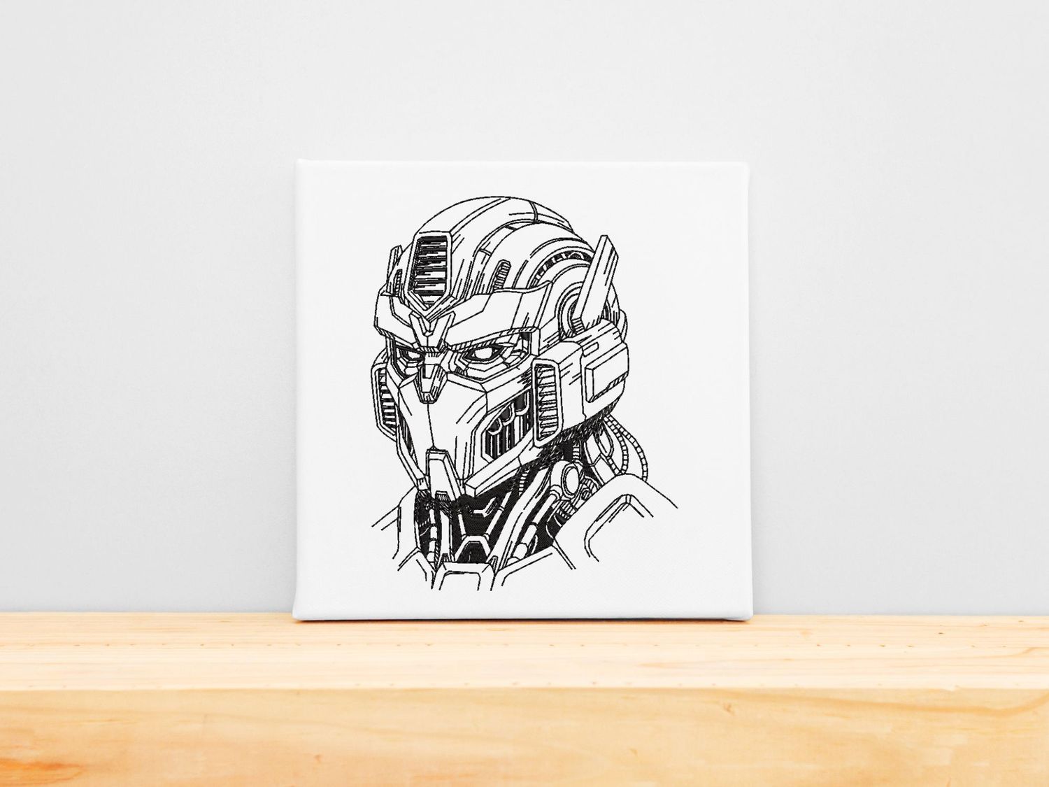 High-precision black machine embroidery of a detailed futuristic mecha robot head on a white stretched canvas frame.