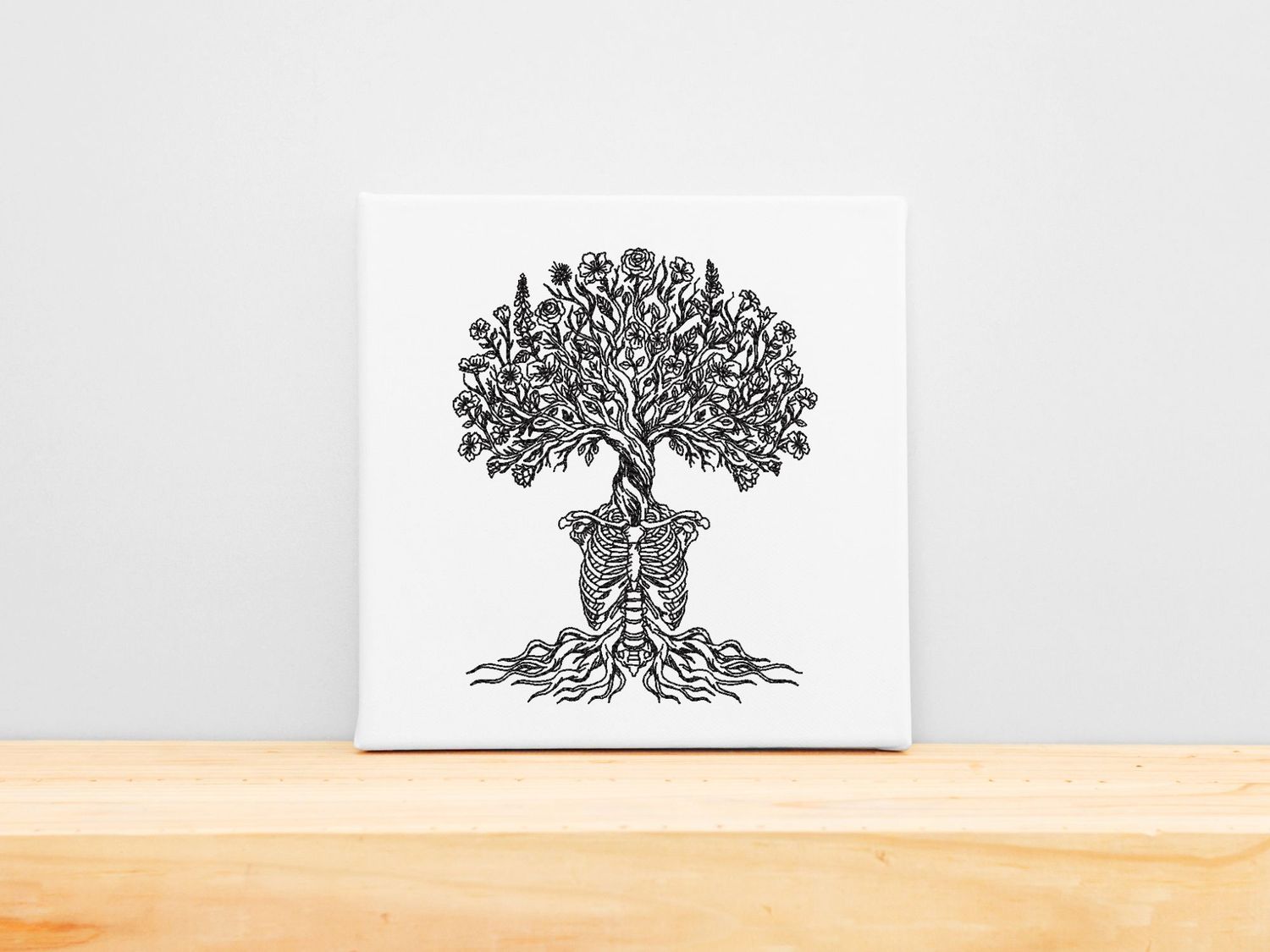 High-precision black embroidery of a human ribcage growing into a blooming floral tree on a white stretched canvas frame.