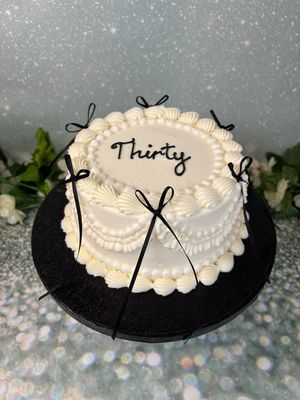 Cream Round Cake With Black Bows