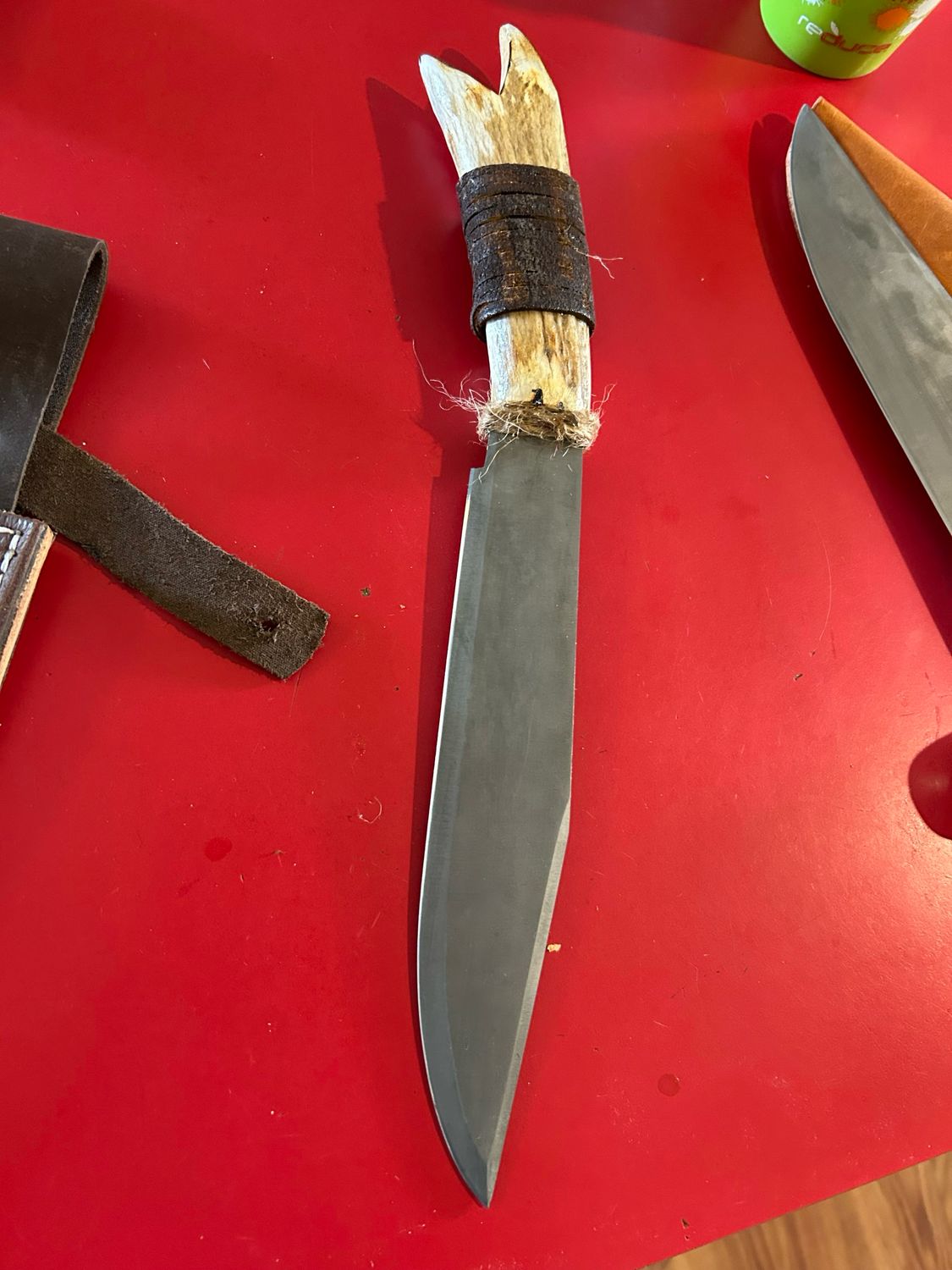Legends of the Fall replica knife with carbon steel blade and elk antler handle on red background