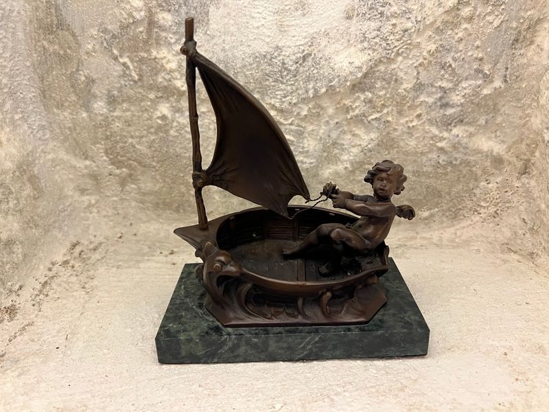 ​Bronzen sculptuur van Cherubijntje in boot op groen marmeren sokkel.  Kunstenaar: Auguste Moreau (1834-1917)