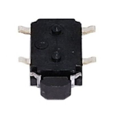 Black SMD switch shaped like a flat tortoise with four metal legs and switch head with metal should…