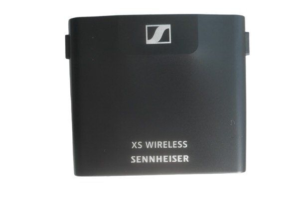 Black cover for a AA battery compartment of a Sennheiser XSW Wireless Bodypack shown on a white background  