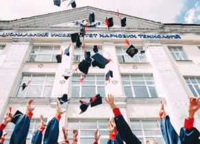 high school graduates in caps and gowns celebrating by tossing caps after graduation ceremony