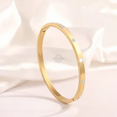 Gold stainless steel bangle with delicate inlaid gems
