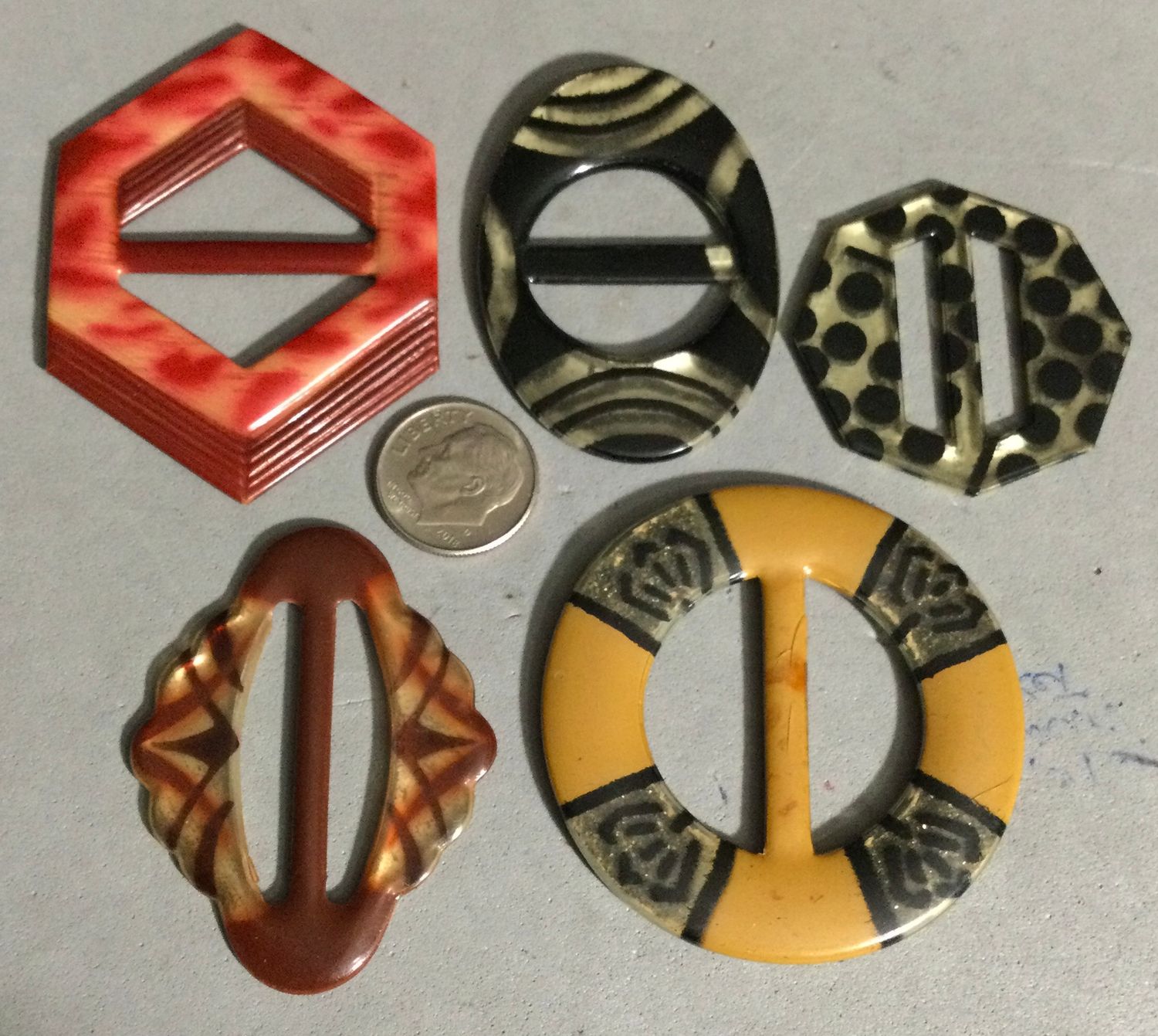 FIVE CELLULOID TIGHT TOP BUCKLES, including GLOWS