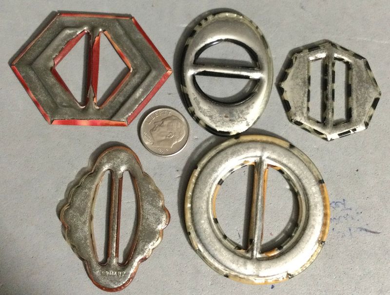 FIVE CELLULOID TIGHT TOP BUCKLES, including GLOWS