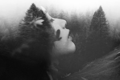 Photographie noir et blanc. Double exposition. Femme et forêt