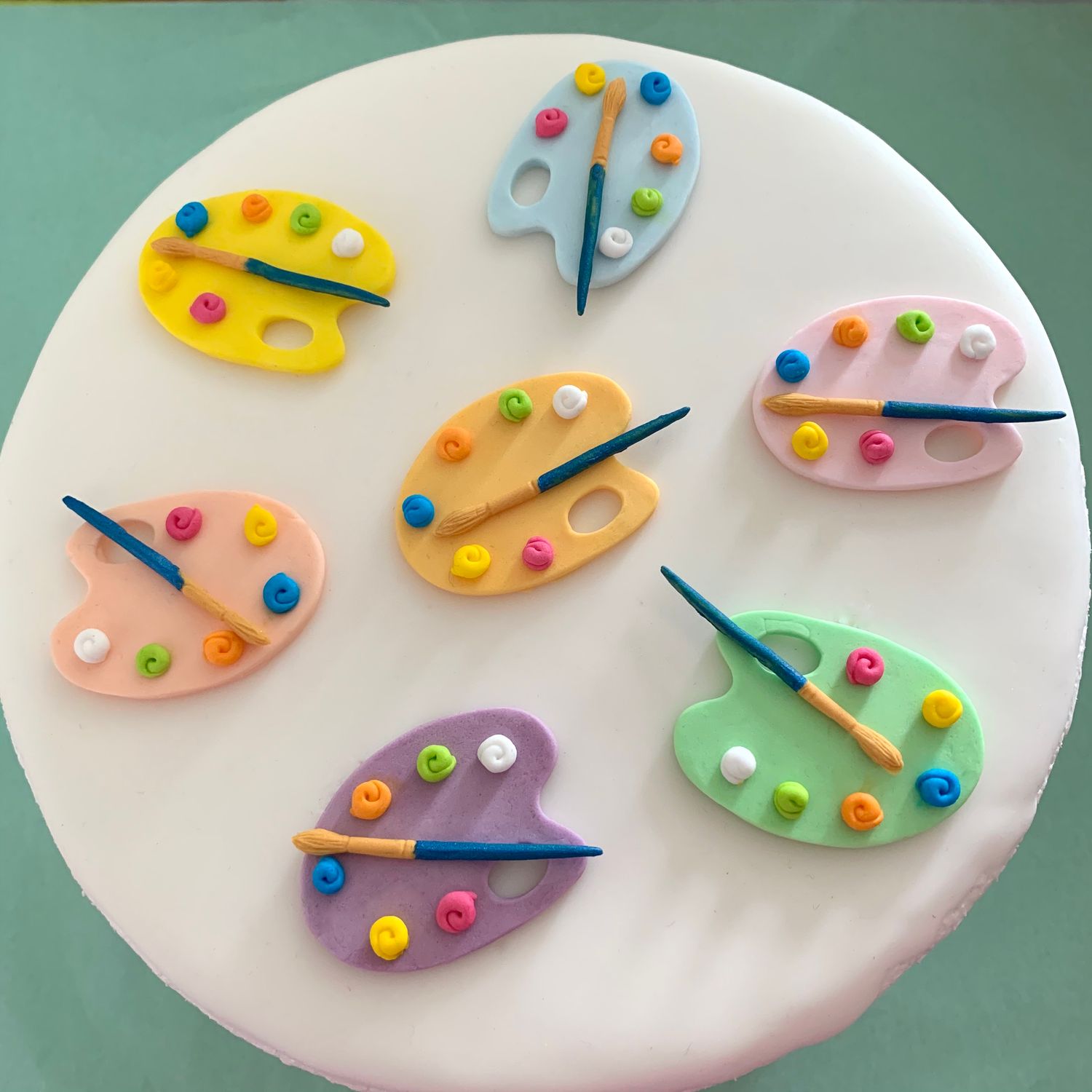 Eight inch white iced cake illustrating paint palettes.