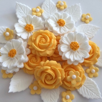 Apricot coloured roses, large hand-painted white daisy style flowers, small apricot coloured flowers with white sugar pearl centres, white leaves.