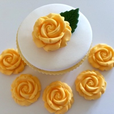 Cupcake illustrating apricot roses with a dark green rose leaf.