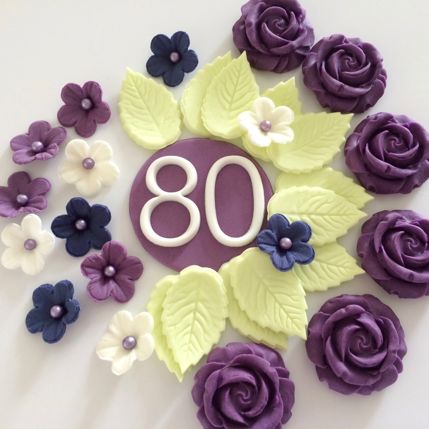 Purple 80 plaque with purple roses, pale green leaves and small flowers.