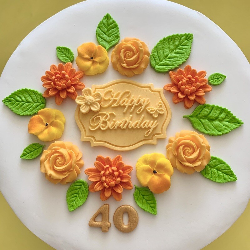 Apricot coloured Happy Birthday plaque with roses, dahlias, violas, green leaves and a gold 40 number.