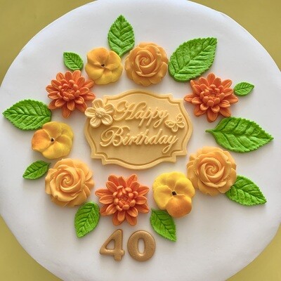 Apricot coloured Happy Birthday plaque with roses, dahlias, violas, green leaves and a gold 40 number.