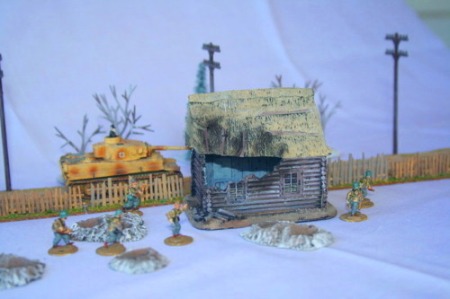 Damaged log cabin with high peaked thatched roof