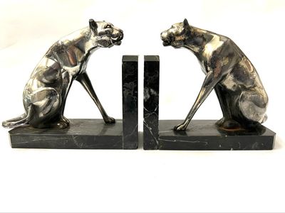 A rare pair of Art Deco panther-shaped bookends, circa 1925, made of nickel-plated metal on marble bases. The metal is heavily worn, and one ear is damaged.