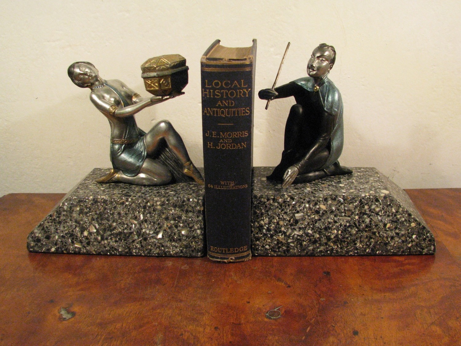 Buchstützen mit Magier und Assistentin um 1925 auf Steinsockeln, pair of bronzed metal book ends of sculptured magician and lady assistent on marble base