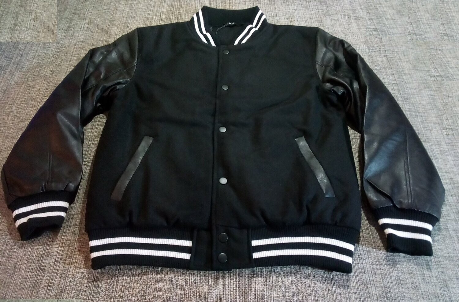 Un Blouson Teddy Noir de "Taille 48/50", avec Manche Simili Cuir, Doublure Intérieure Entièrement en Laine, Deux Poches Latérales.