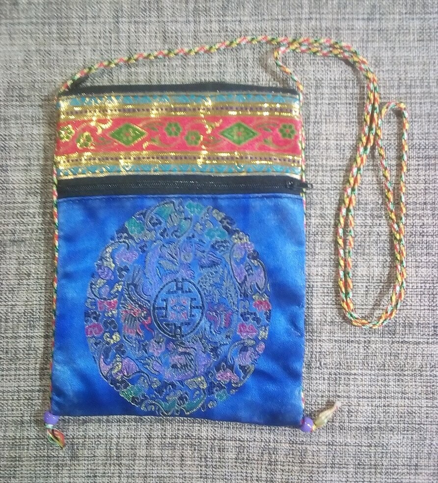 Une Pochette en Style "Indien Bleu" avec des Cercles Représentants des Symboles Diverses sur un Fond de Couleur "Bleu", en Dimension de 15.5 x 19 cm.