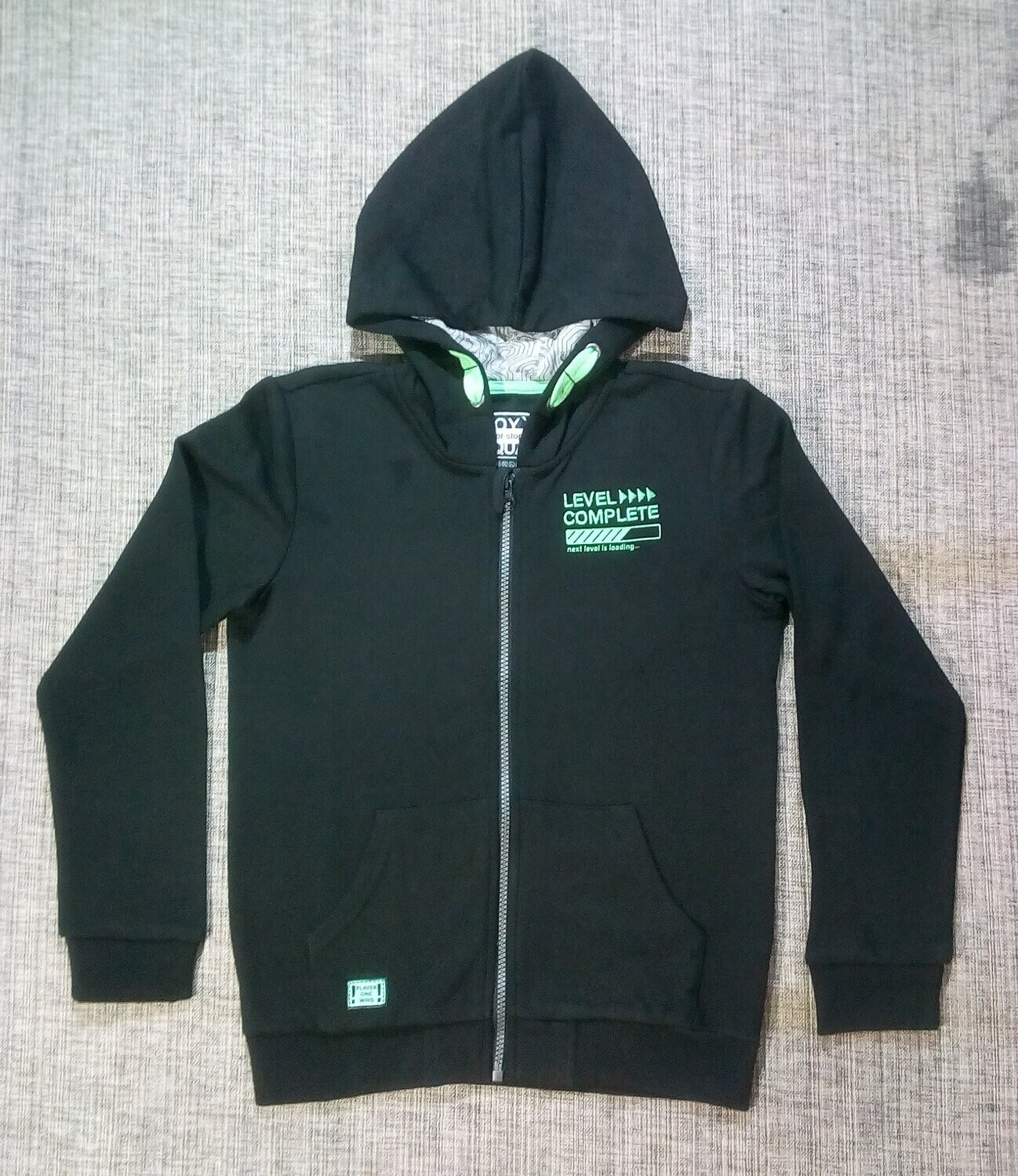 Un Sweat Un Sweat "Noir", de Taille 40/42, en Couleur Unique, un Logo Côté Coeur de "Level >>>> Complete...", de Couleur Vert Fluo.