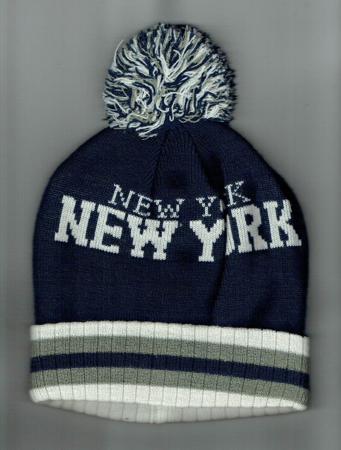 Un Bonnet de Couleur Bleu Marine avec "Revers et Pom-Pom" une Déco Écrit "New York" et d'une Doublure Polaire