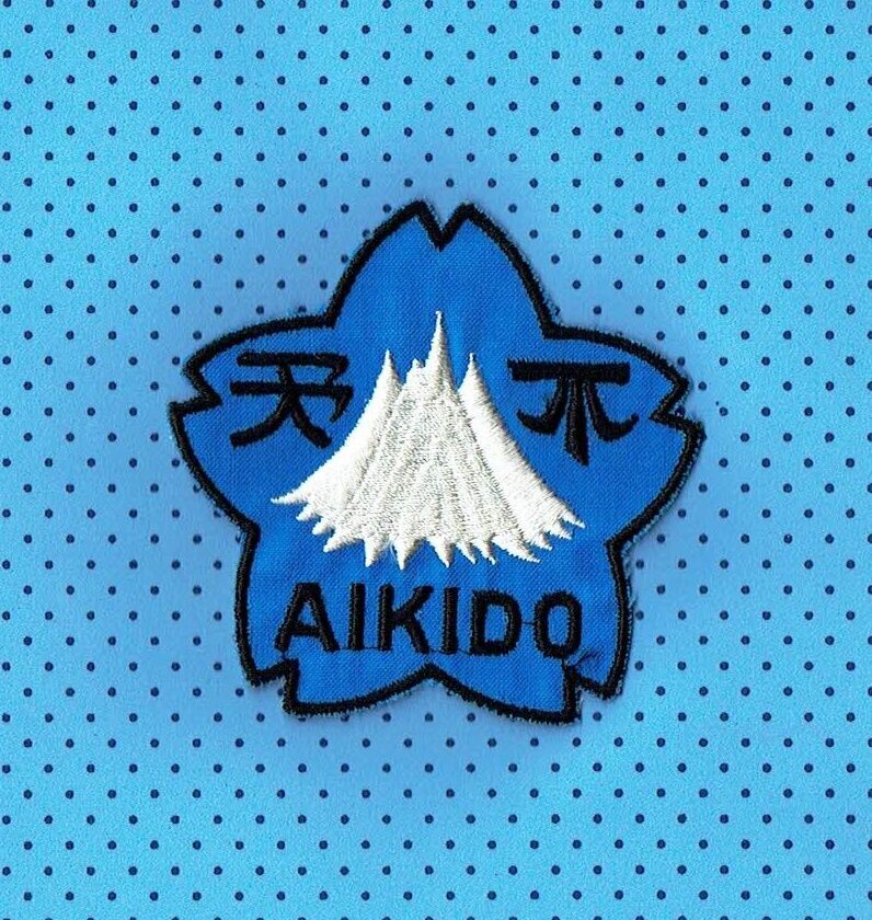 Patch/Écusson Broderie à Coudre - Une Montagne Blanc et Logo "Aïkido" dans une Forme de Pentagone sous un Fond Bleu pour une Dimension 8 x 8 cm