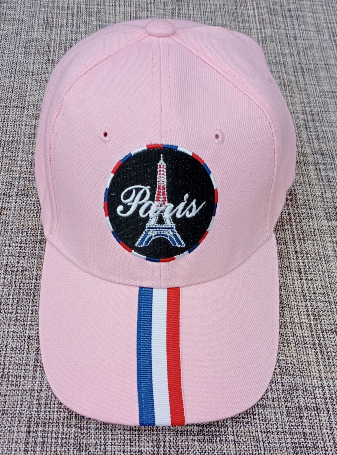 Une Casquette Rose Claire avec une Broderie "Tour Eiffel, Paris" dans un Cercle Fond noir au Contour Couleur Française "BBR" et sur sa Visière Bombée une Bande au Couleur "Française"