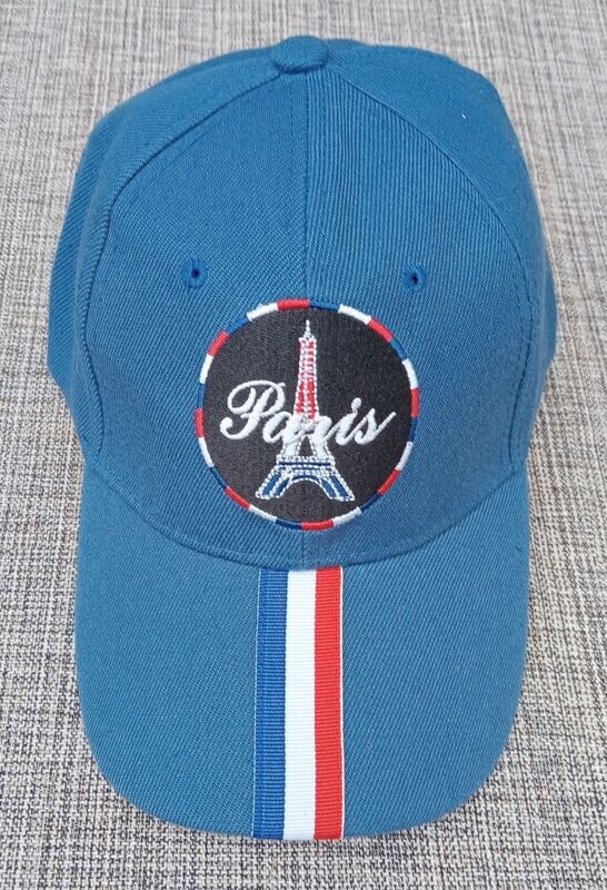 Une Casquette Bleu Marine avec une Broderie Une Casquette Bleu Marine avec une Broderie "Tour Eiffel, Paris" dans un Cercle Fond noir au Contour Couleur Française "BBR" et sur sa Visière Bombée une Bande au Couleur "Française"