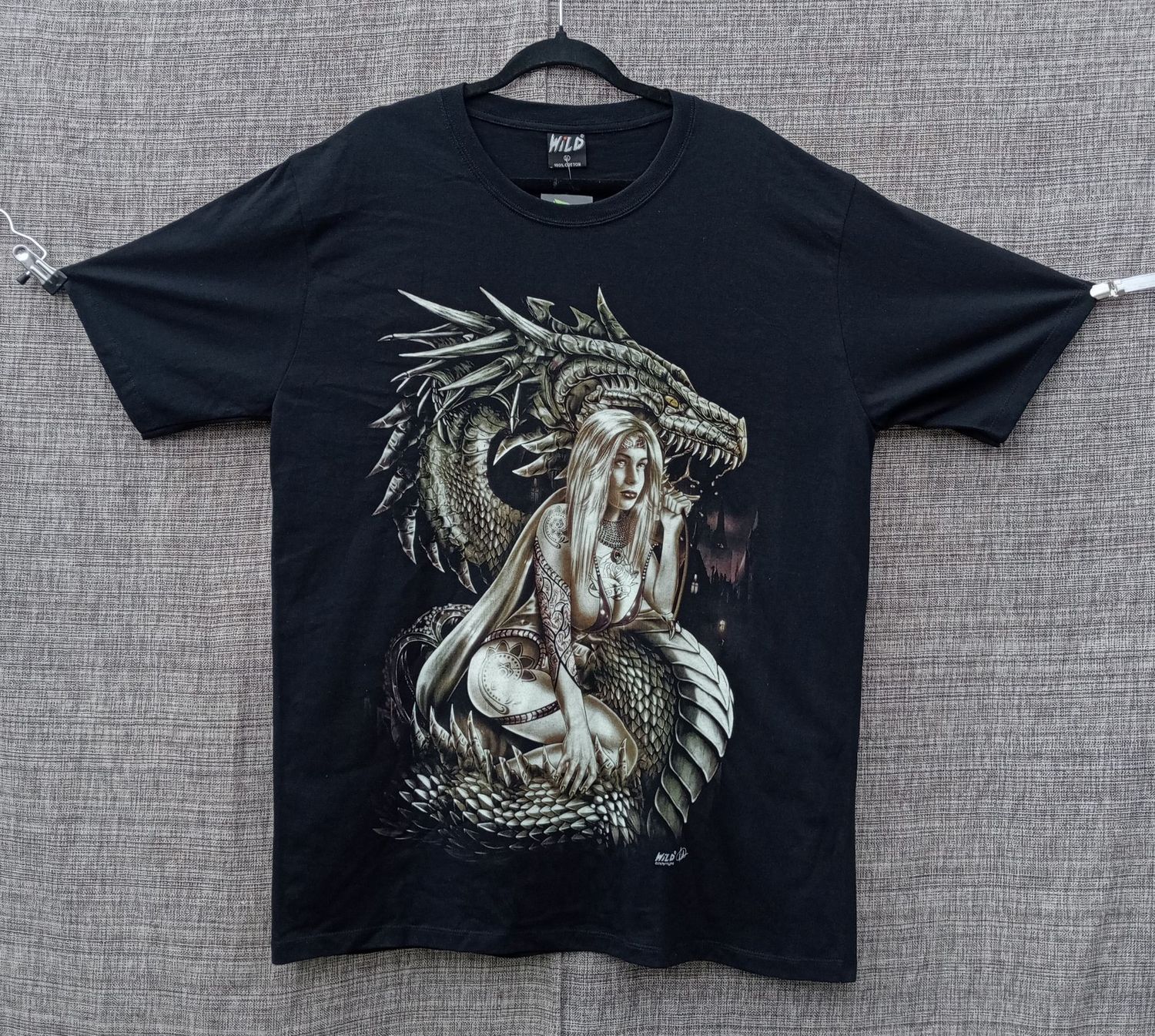 T-Shirt - XL - Une Girl en Maillot, Tatouée de Roses, Symboles et Assis sur son Dragon Gris/Marron avec Ville en Font Marron