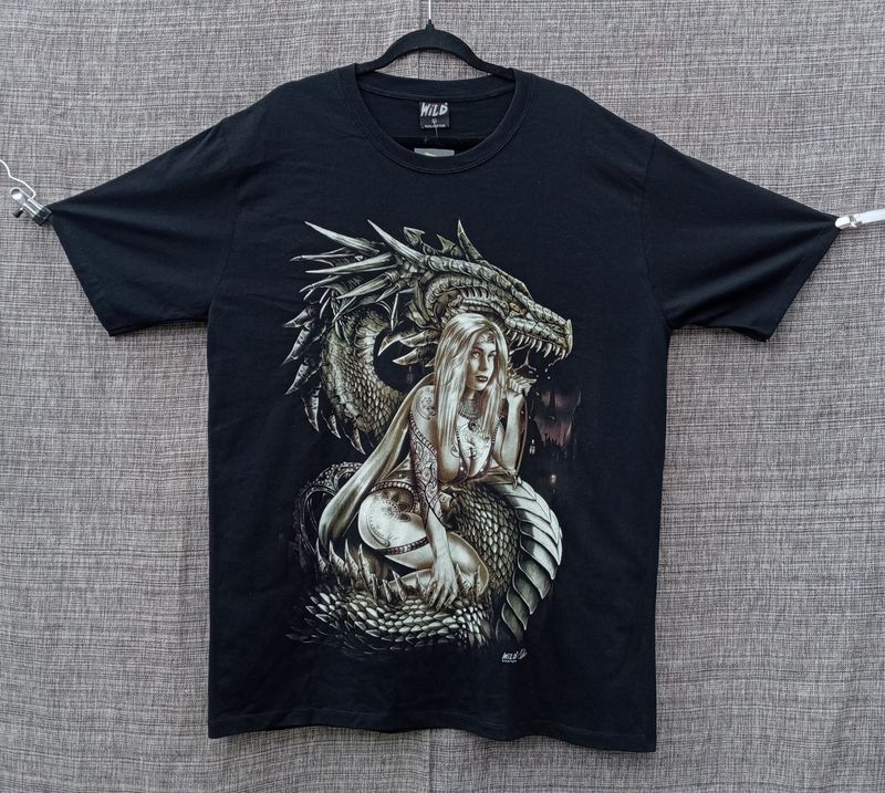 T-Shirt - XL - Une Girl en Maillot, Tatouée de Roses, Symboles et Assis sur son Dragon Gris/Marron avec Ville en Font Marron