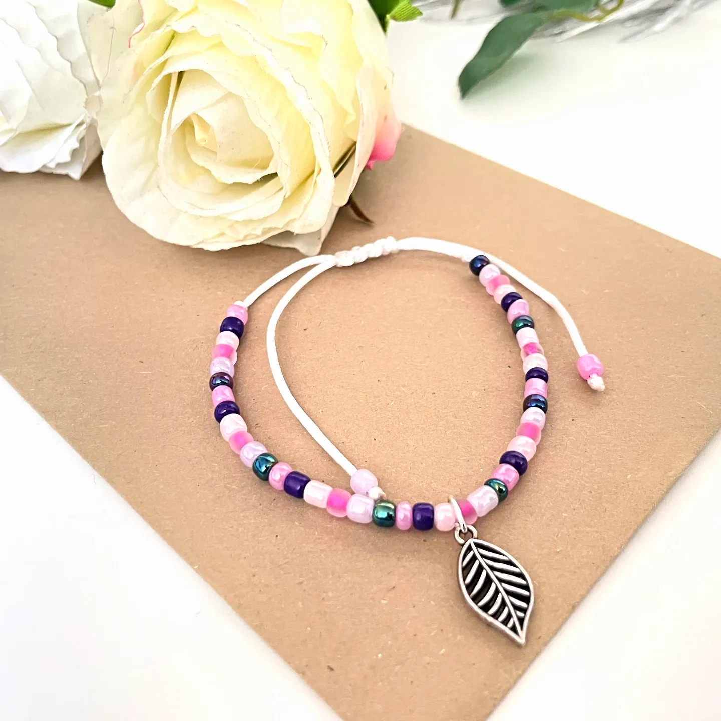 dünnes perlenarmband silberfarbener blattanhänger rosa pink handgefädelt