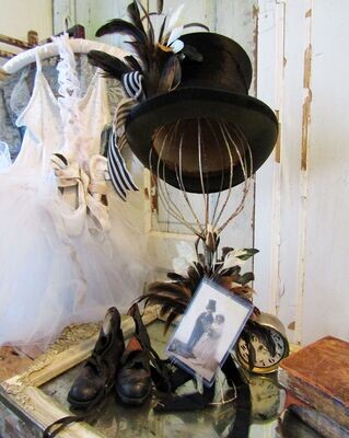 Antique black top hat on hat rack with antique postcard Antique black top hat on hat rack with antique postcard