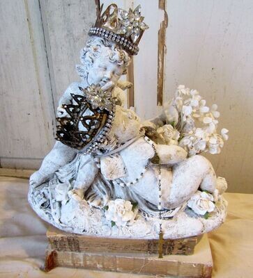 Cherubs with crowns playing antique plaster statue with white flowers