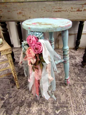Vintage Style wood stool painted blue with layers under tones embellished with tattered rag fabric lace and florals anita spero design