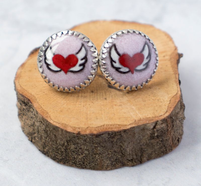 Hand painted with enamel, pink and red winged heart studs made from sterling silver.