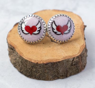 Hand painted with enamel, pink and red winged heart studs made from sterling silver.