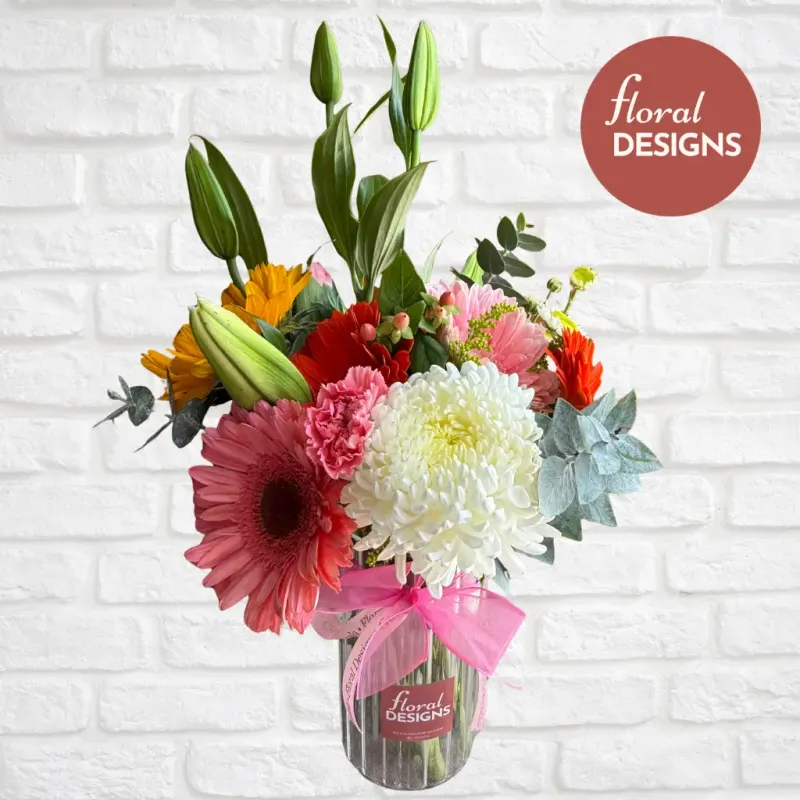 Arreglo floral de gerberas rosadas, lirios, claveles y crisantemos blancos en florero de vidrio, Floral Designs Guatemala.