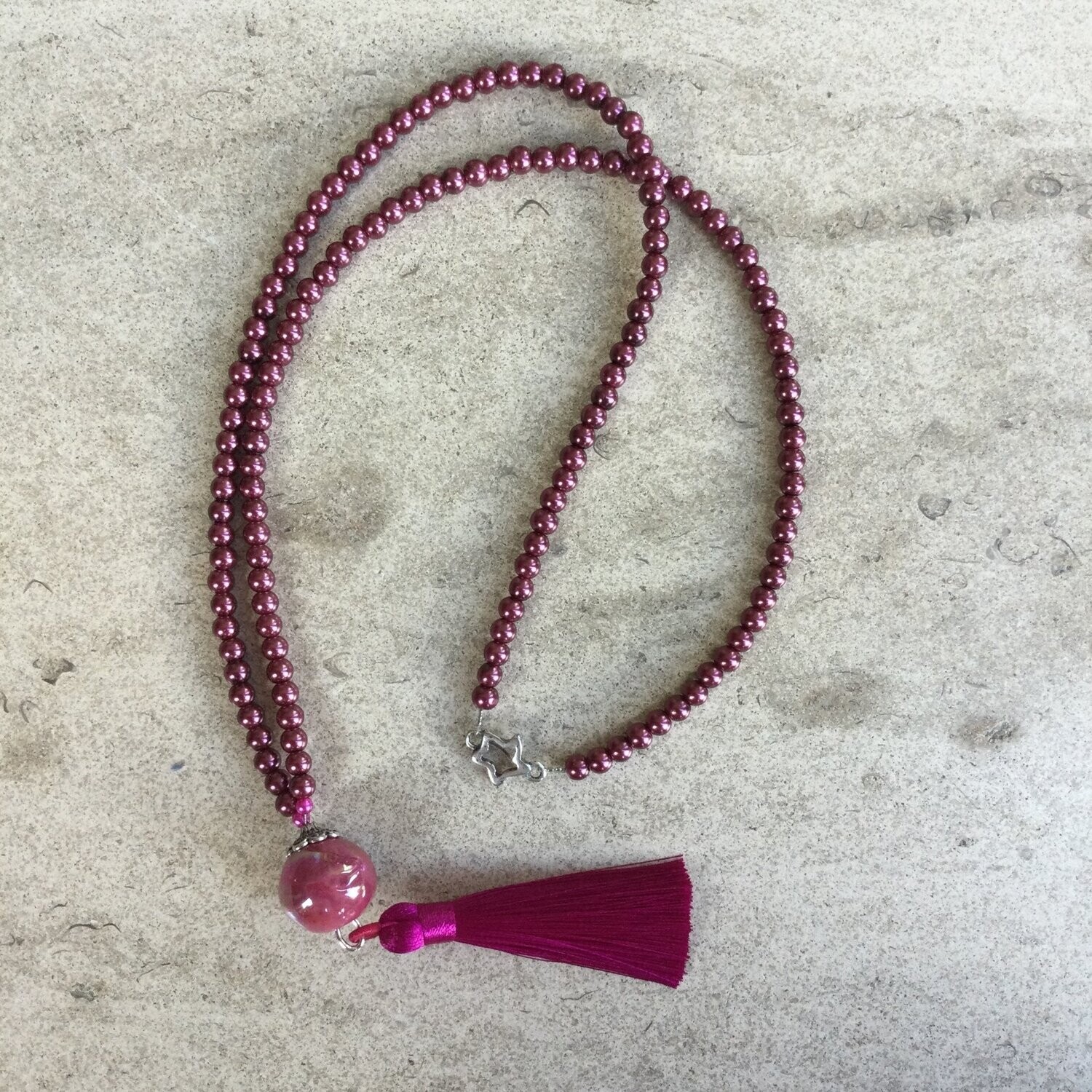 Lange fuchsia halsketting met satijn kwispel.