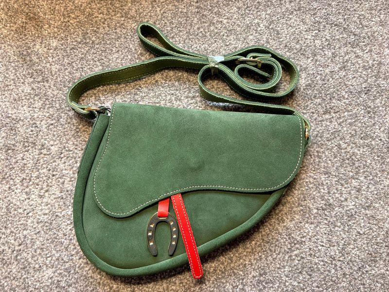 Handtasche in Sattelform grün mit rotem Akzent