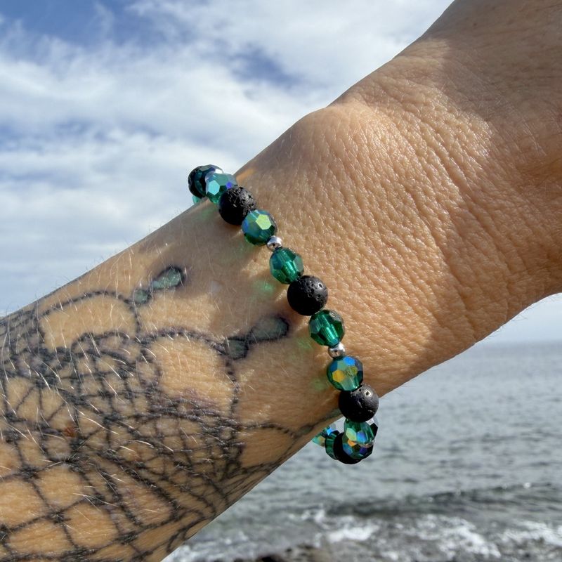 Lava Armband mit grünen Kristallen getragen am Meer auf Lanzarote