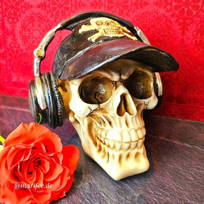 Totenkopfskulptur mit Basecap und Kopfhörer, Steampunk