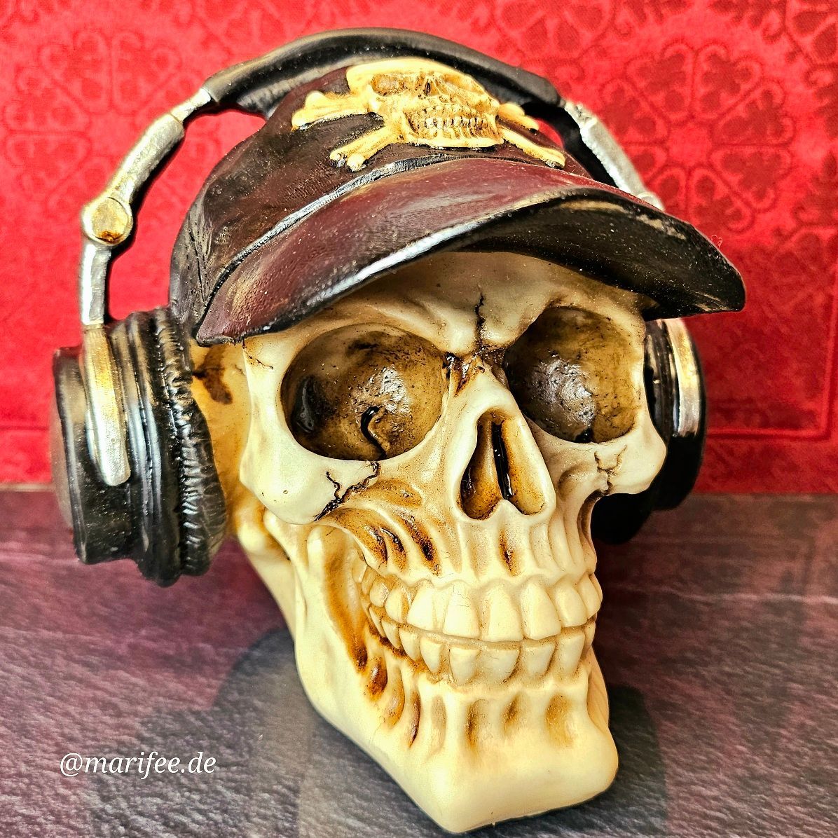 Totenkopfskulptur mit Basecap und Kopfhörer, Steampunk