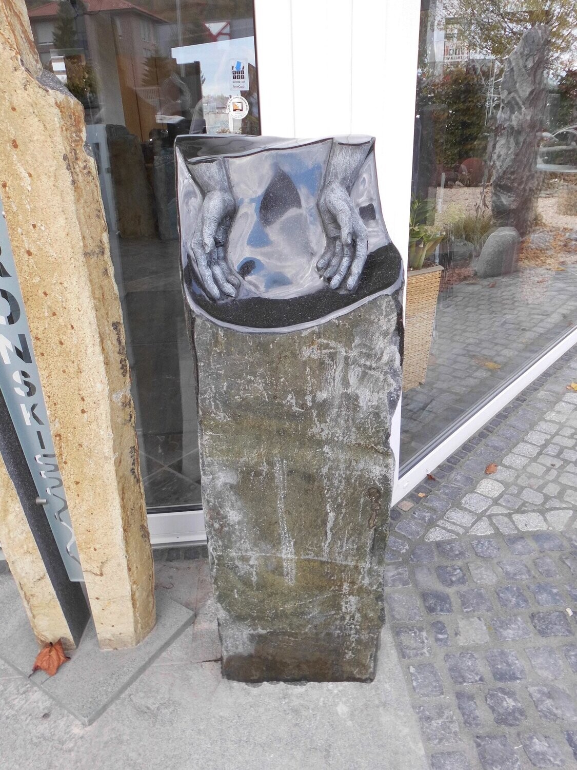 Basaltsäule iran. - grün, teilpoliert mit Ornament "Hände"