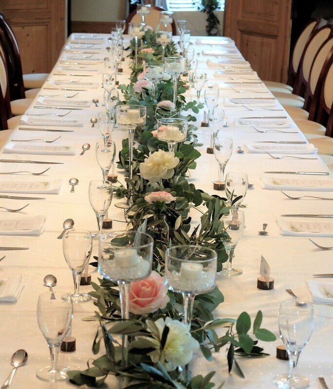 Blütengläser in Grüngirlande