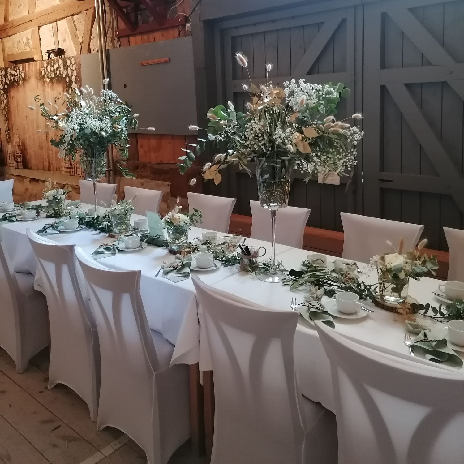 Glaspokal mit Eukalyptus und Ranke mit Blütengläsern