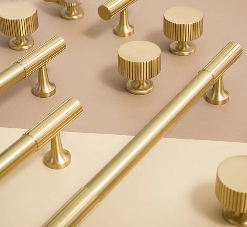 Matte gold brass bar handle with a line pattern