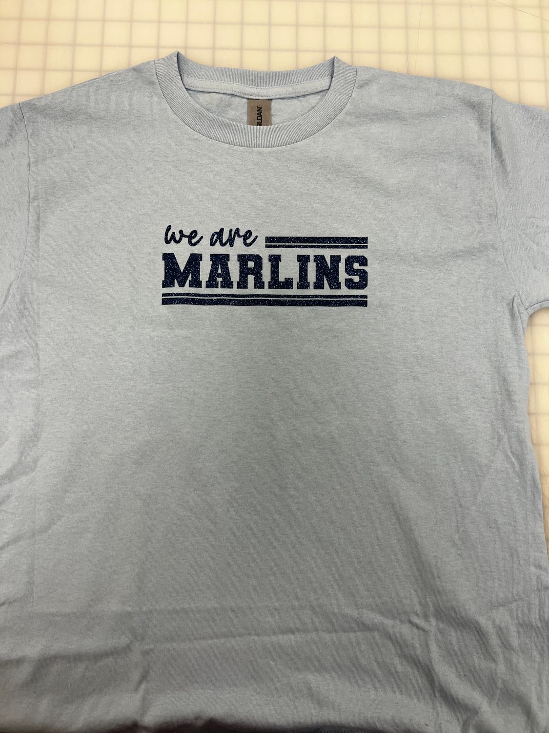 (Youth Medium) We Are Marlins Glitter Navy   - Short Sleeve Light Blue