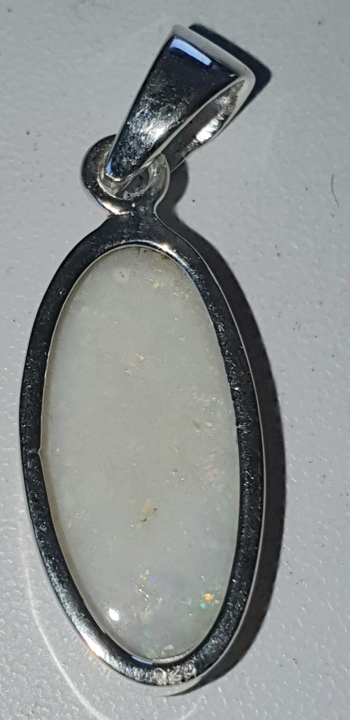 P27a Coober Pedy White Solid Opal with reds, orange, green & blue flashes
12mm across x 25mm opal size