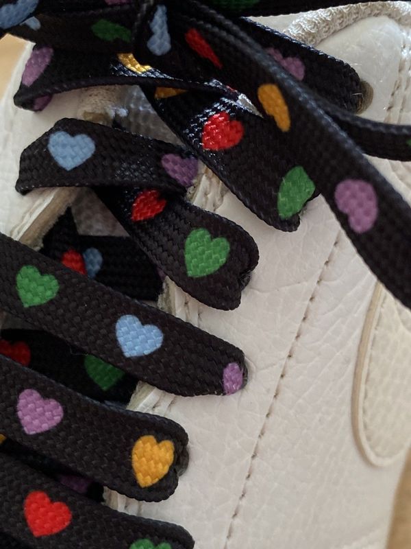 Multicolored heart shoelaces on a black background